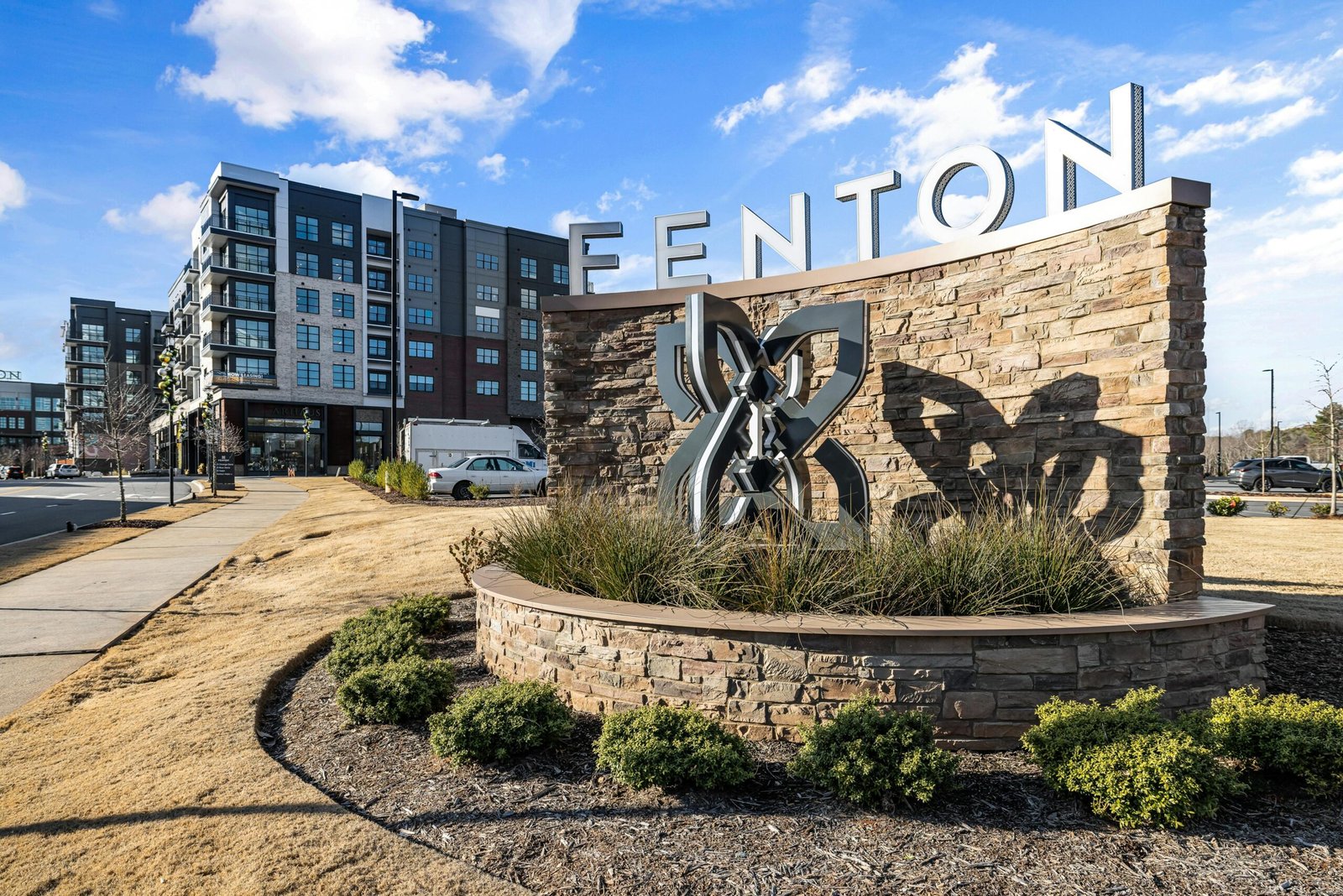 A contemporary apartment complex near Fenton with a prominent sign and pathway.